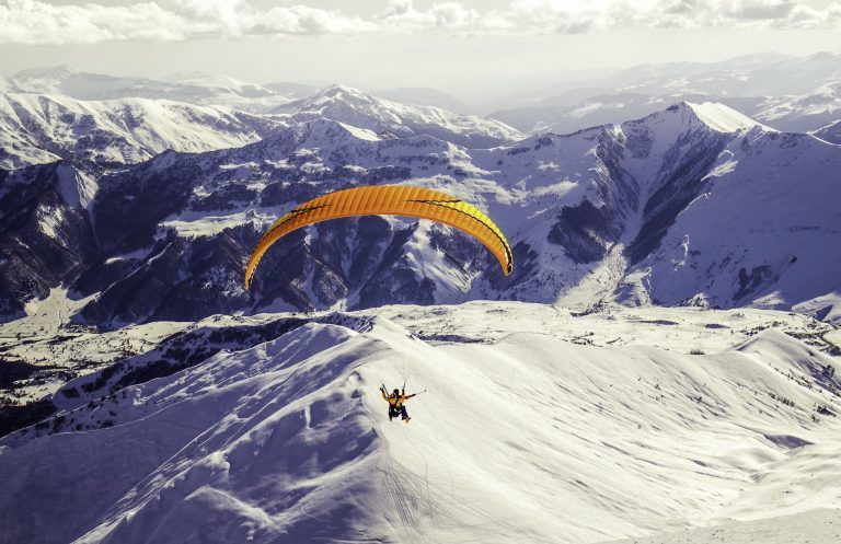 paragliding-boven-besneeuwde-bergen