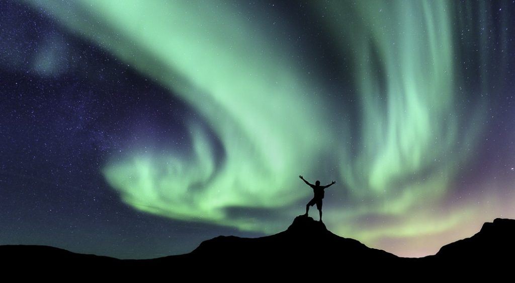 manMan geniet van Noorderlicht-op-berg-met-noorderlicht-fins-lapland