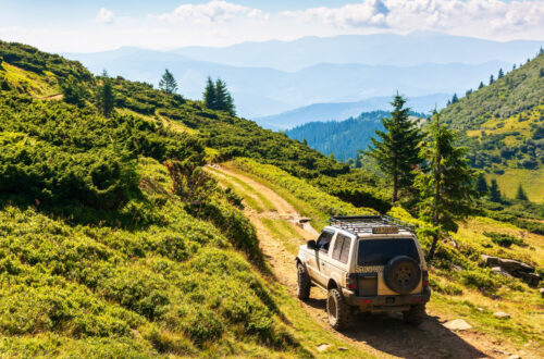 yasinya, ukraine - AUG 22, 2020: 4x4 running on the mountain road in carpathians. beautiful summer landscape. view in to the distant valley. sunny morning weather